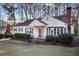 Inviting one-story home featuring a brick chimney, lush greenery, and a cozy, classic facade at 1258 Merry Ne Ln, Atlanta, GA 30329