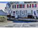 Townhome exterior showcasing stone accents and red shutters, enhanced by a tidy parking and landscaped entrance at 4008 Bayside Cir, Atlanta, GA 30340