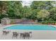 Community pool with lounge chairs, tables, and a tennis court surrounded by trees at 4008 Bayside Cir, Atlanta, GA 30340