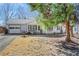 Well-maintained home featuring a covered porch, garage, and landscaped yard, shaded by a large tree at 1006 Walnut Dr, Lawrenceville, GA 30044