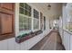 Close-up of a quaint front porch featuring decorative flower boxes, patterned carpet, and hanging lights at 1006 Walnut Dr, Lawrenceville, GA 30044