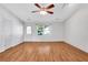 Bright living room with wood flooring, a ceiling fan, and natural light from the window at 1006 Walnut Dr, Lawrenceville, GA 30044