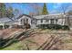 Rear exterior view featuring the home's backyard, showcasing the patio area with a pergola and mature shrubbery at 1006 Walnut Dr, Lawrenceville, GA 30044