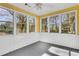 Enclosed sunroom has a neutral-colored floor, a large window and white beadboard paneling at 1006 Walnut Dr, Lawrenceville, GA 30044