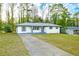 Charming one-story home featuring white brick, a long driveway, and a well-manicured lawn at 1877 Glenmar Dr, Decatur, GA 30032