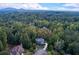 An aerial view captures the home's secluded setting among towering trees at 203 Glenrise Ct, Woodstock, GA 30188