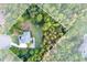 An aerial view of the property shows a lovely landscaped lawn and the surrounding private wooded acreage at 203 Glenrise Ct, Woodstock, GA 30188