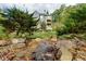 Wooded backyard featuring a stone-lined water feature and lush landscaping at 203 Glenrise Ct, Woodstock, GA 30188