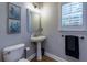 Powder room features a pedestal sink, decorative mirror, and a toilet at 203 Glenrise Ct, Woodstock, GA 30188