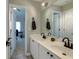 Dual vanity bathroom with framed mirror, with view to bedroom with desk and chair at 203 Glenrise Ct, Woodstock, GA 30188