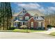 Charming two-story home with a brick and gray exterior, lush lawn, and manicured landscaping creates excellent curb appeal at 203 Glenrise Ct, Woodstock, GA 30188