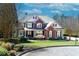 Charming two-story home with a brick and gray exterior, lush lawn, and manicured landscaping creates excellent curb appeal at 203 Glenrise Ct, Woodstock, GA 30188