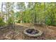 Stone fire pit area surrounded by low stone walls and woods at 203 Glenrise Ct, Woodstock, GA 30188