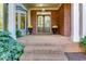 Inviting front porch featuring a brick floor, double entry doors, and decorative flower planters creating an elegant entrance at 203 Glenrise Ct, Woodstock, GA 30188