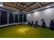 Indoor golf room with artificial turf, a projector, and several golf bags at 203 Glenrise Ct, Woodstock, GA 30188