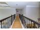 Hallway features a wooden floor, dark railing, and white trim with an open floor plan at 203 Glenrise Ct, Woodstock, GA 30188