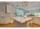 A spacious kitchen featuring white cabinets, marble countertops, tile backsplash, and stainless steel appliances at 203 Glenrise Ct, Woodstock, GA 30188