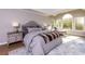 Comfortable main bedroom featuring a tray ceiling and an abundance of natural light from the large windows at 203 Glenrise Ct, Woodstock, GA 30188