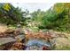 Wooded backyard featuring a stone-lined water feature with a small stream at 203 Glenrise Ct, Woodstock, GA 30188