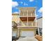 Rear exterior view showcasing the three-story deck and garage with a sunny sky at 3628 Princeton Ave, Atlanta, GA 30337