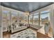 Bright sunroom featuring a blue painted ceiling, hardwood floors, large windows and a neutral colored sofa with pillows at 112 Bluestone Ct, Acworth, GA 30101