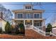 Attractive two-story home featuring a welcoming front porch with ample seating and a brick facade at 303 Bass Se St, Atlanta, GA 30315