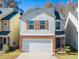 Two-story home featuring a brick-base, attached garage, and light brown shutters at 5171 Hanover St, Atlanta, GA 30349