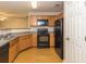 Well-lit kitchen featuring light wood cabinets, grey countertops, and black appliances at 5171 Hanover St, Atlanta, GA 30349