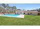 Backyard view of pool and the home's rear white brick exterior and lush green lawn at 4554 Mountain Creek Ne Dr, Roswell, GA 30075