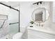 This bathroom features a decorative mirror, marble shower and black hardware at 4554 Mountain Creek Ne Dr, Roswell, GA 30075