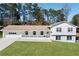 Inviting split-level home featuring a manicured lawn, white painted brick, and charming front porch at 4554 Mountain Creek Ne Dr, Roswell, GA 30075