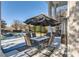 Covered patio with outdoor dining set and grill, overlooking a pristine pool and landscape at 490 Birkdale Dr, Fayetteville, GA 30215