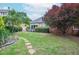 A verdant backyard with stone pathway, mature trees, landscaping and a small deck at 11385 Donnington Dr, Duluth, GA 30097