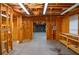 Spacious unfinished basement, featuring exposed wooden framing, insulation, and workbench area at 11385 Donnington Dr, Duluth, GA 30097