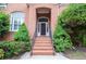 Inviting front entrance with brick steps and railing, surrounded by lush landscaping at 11385 Donnington Dr, Duluth, GA 30097