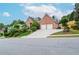 Beautiful exterior view of a red brick home with an attractive, sloped driveway leading to a two-car garage at 11385 Donnington Dr, Duluth, GA 30097
