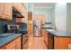 Gourmet kitchen features stainless appliances, light wood cabinetry, dark counters and hardwood floors at 11385 Donnington Dr, Duluth, GA 30097