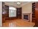 Inviting living room features a brick fireplace and custom built-in shelving, with large sunny windows at 11385 Donnington Dr, Duluth, GA 30097