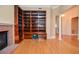 Spacious living room with hardwood floors, brick fireplace, and custom built-in shelving at 11385 Donnington Dr, Duluth, GA 30097