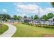 A community playground and pool area with lush green grass and mature shade trees at 11385 Donnington Dr, Duluth, GA 30097