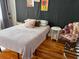 Comfortable bedroom with hardwood floors, cozy bedding, and artistic wall decor at 23 Poplar St, Porterdale, GA 30014