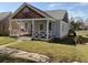 Cozy home featuring a quaint front porch with decorative railings and inviting curb appeal at 23 Poplar St, Porterdale, GA 30014