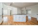 Open kitchen with island cooktop, white cabinets, hardwood floors, and a view to the living space at 3968 Belle Glade Ct, Snellville, GA 30039