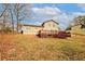 A home's backyard with a wooden deck surrounded by grass and autumn leaves at 4161 Windermere Dr, Lithonia, GA 30038