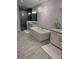 Bright bathroom features a standalone tub with a decorative light fixture, dual vanities, and elegant tile flooring at 323 Concord St, Alpharetta, GA 30009