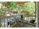 Balcony with a wrought iron table and chairs, offering a view of the surrounding trees at 402 Bainbridge Dr, Atlanta, GA 30327