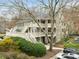 Multi-story building with white balconies and stairs, surrounded by lush landscaping and parking spaces at 402 Bainbridge Dr, Atlanta, GA 30327