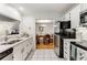 Bright kitchen featuring white cabinets, stainless steel appliances, and view to dining room at 402 Bainbridge Dr, Atlanta, GA 30327