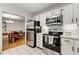 Eat-in kitchen featuring white cabinets, stainless appliances, and view to dining room at 402 Bainbridge Dr, Atlanta, GA 30327