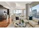 Sunlit living room with modern furnishings, open to a kitchen with stainless steel appliances and city views at 1080 Peachtree Ne St # 2011, Atlanta, GA 30309